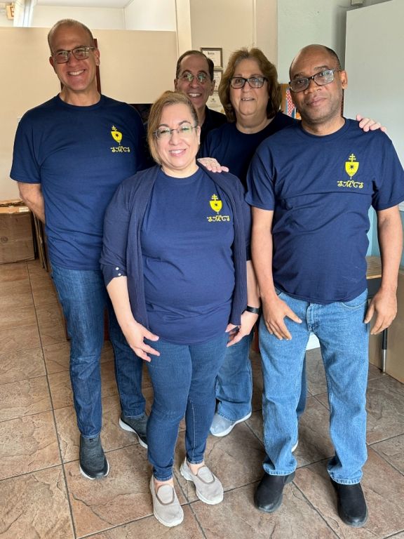 A group of people are posing for a picture and one of them is wearing a t-shirt with the word tivoli on it
