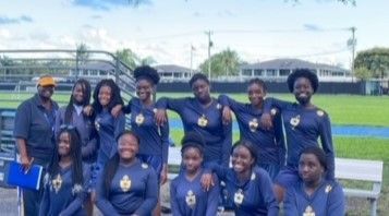 A group of young women are posing for a picture on a field.