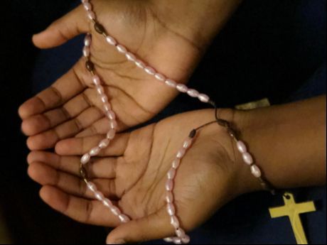 hands holding rosary beads