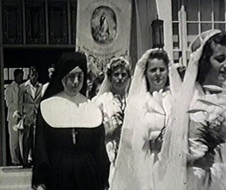 A black and white photo of a nun and a bride