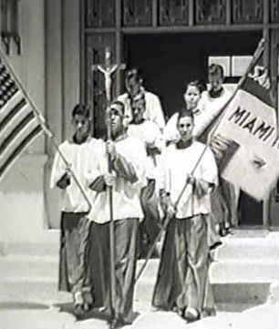 A black and white photo of a group of people holding flags.