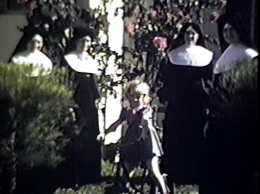 A group of nuns are standing next to a little girl