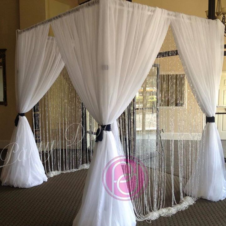 A beautiful and elegant pipe and drape canopy set up at the entrance to an event.