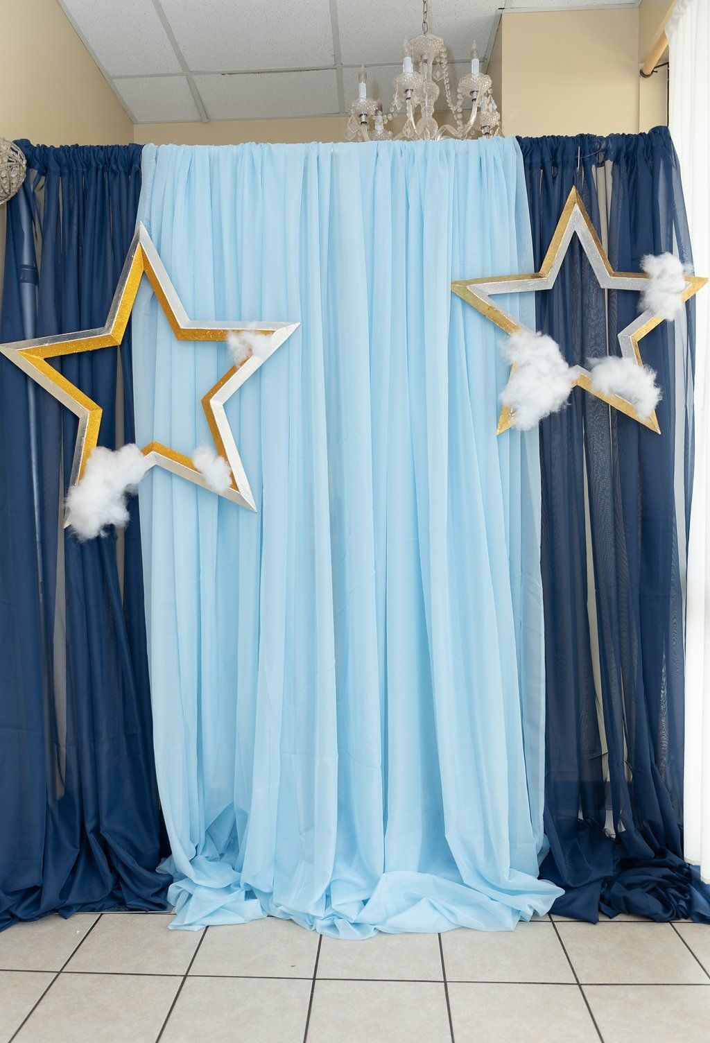 Pipe and drape setup in light and dark blue with star cutouts adorned with cotton clouds.