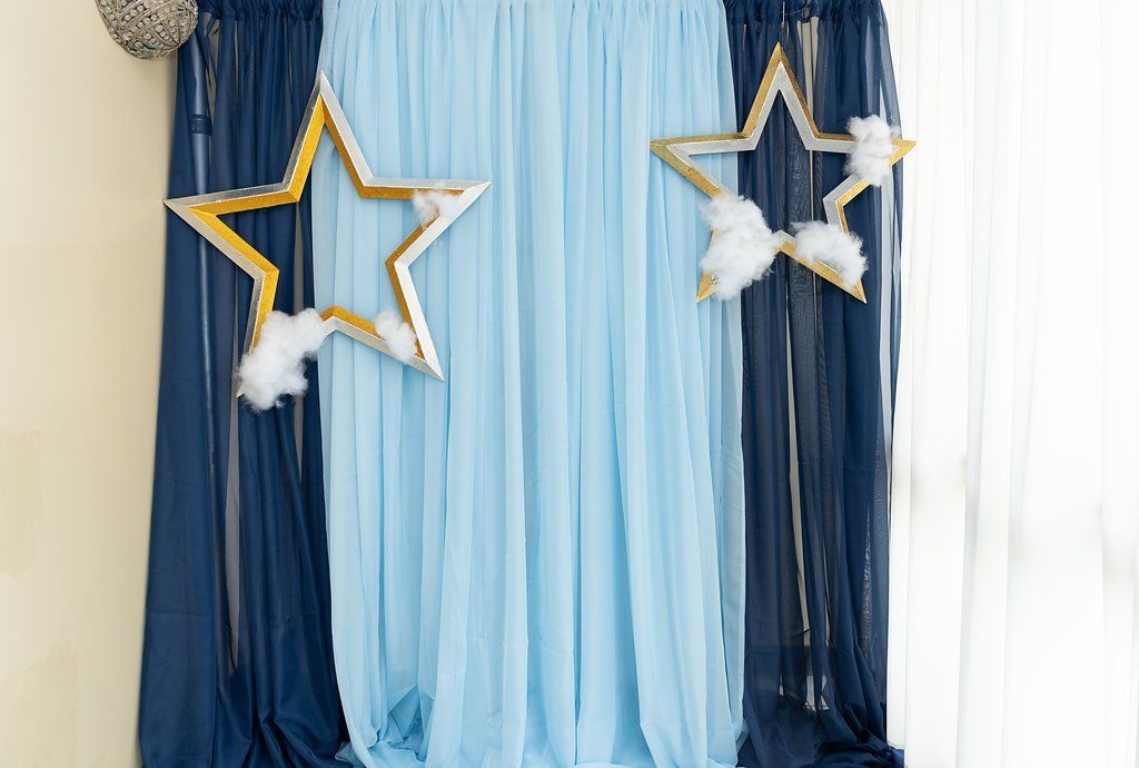 Close up of star cutouts with cotton clouds hanging on draping.