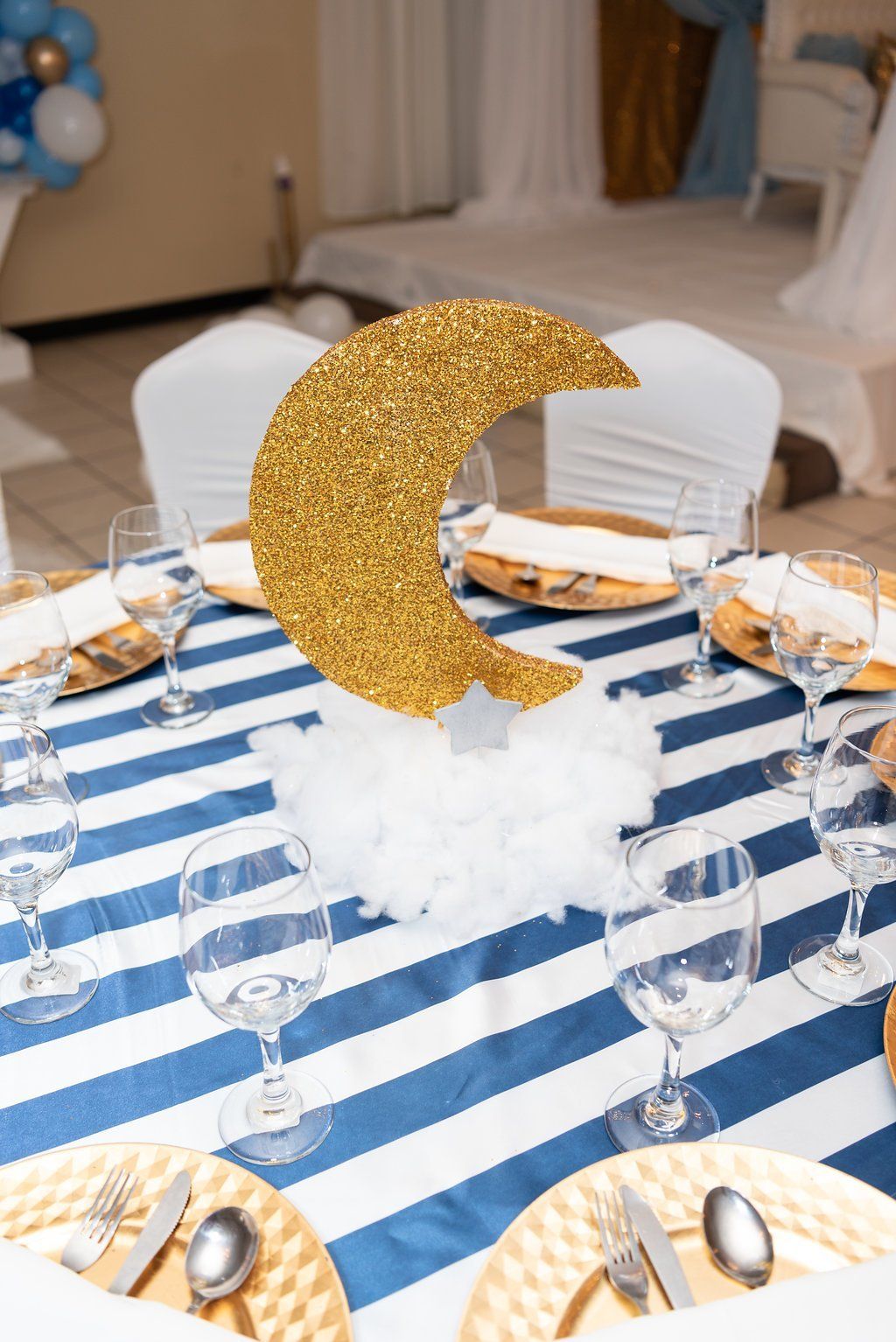 Closeup of a centerpiece with a crescent moon cutout sitting on a cotton cloud.