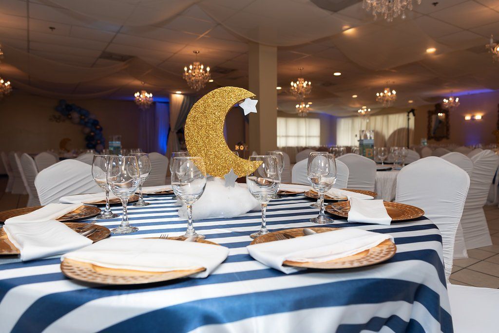 Closeup of a nighttime themed table setup. Centerpiece sits on a cotton cloud with a gold crescent moon and silver star accents.