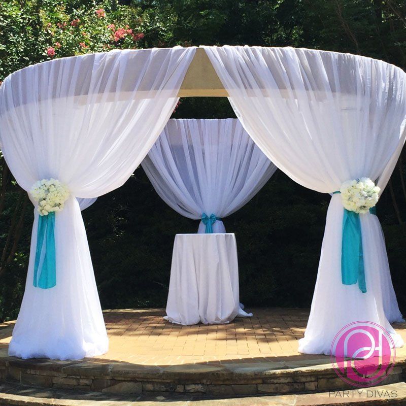 Fabric draping for a Chuppah for an outside wedding with gorgeous flowers at the tying points.