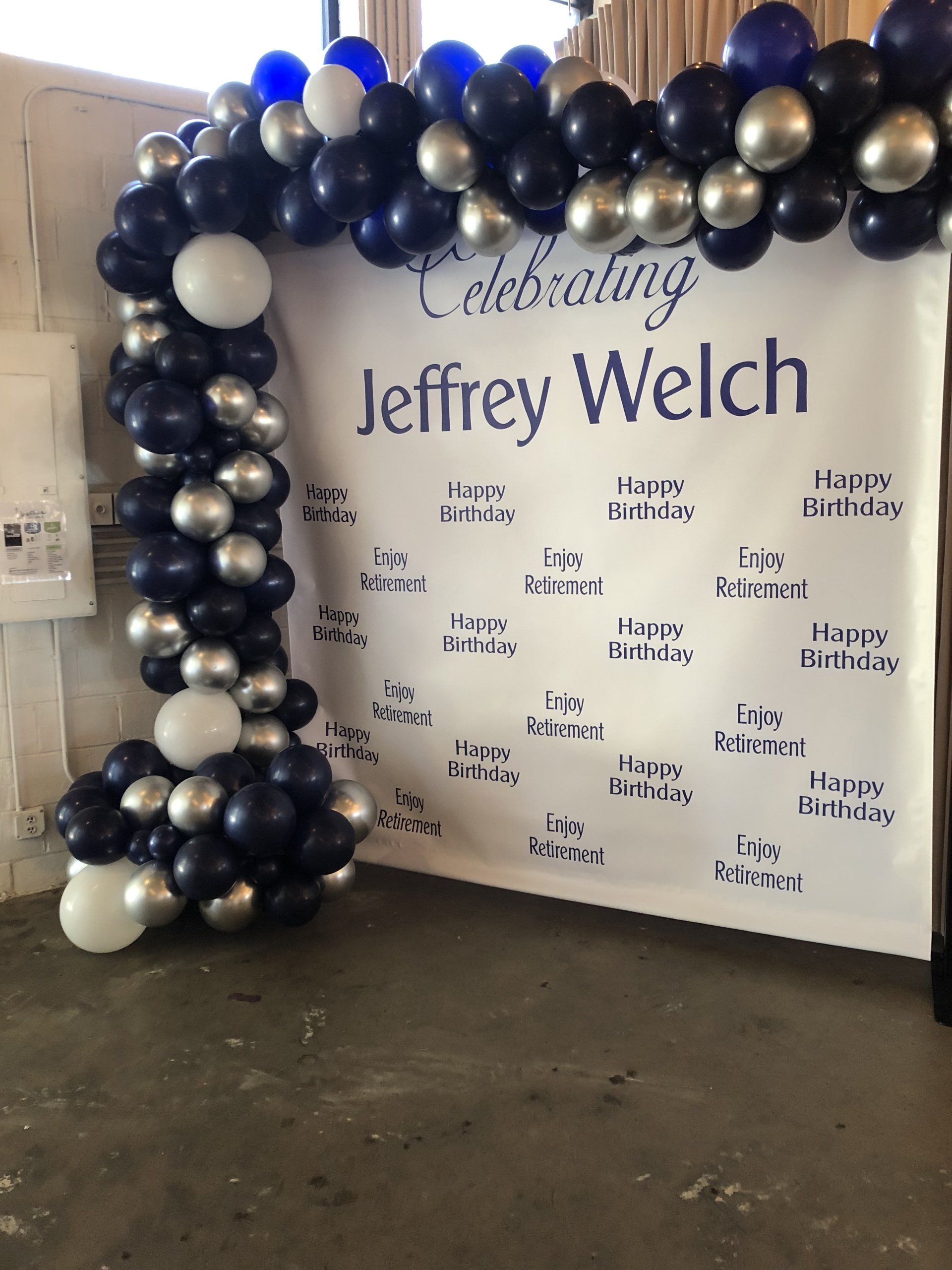 An organic balloon garland frames a celebrity wall.