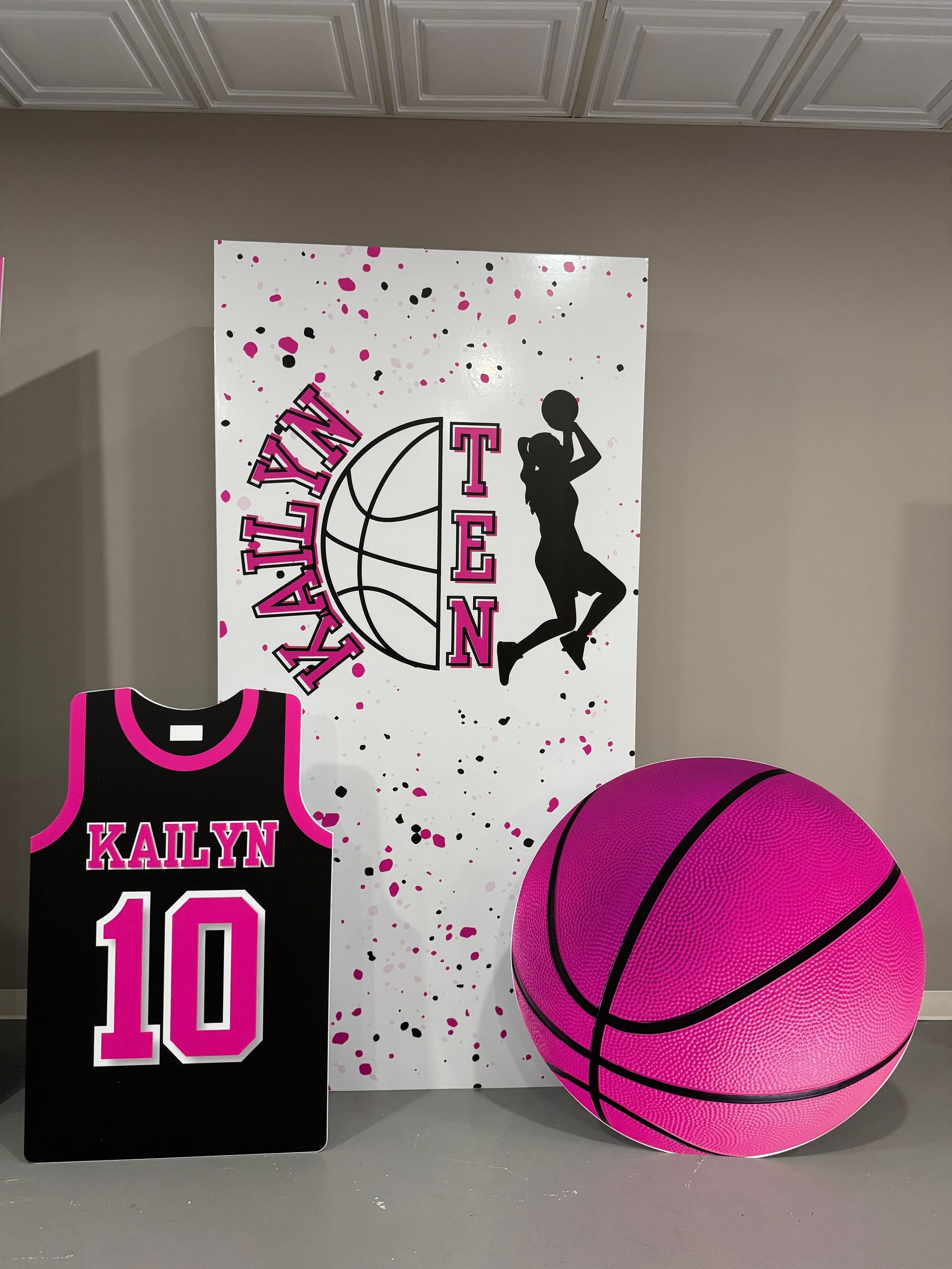 Girls basketball themed party backdrop with pink splatter design and player silhouette for sports birthday celebration