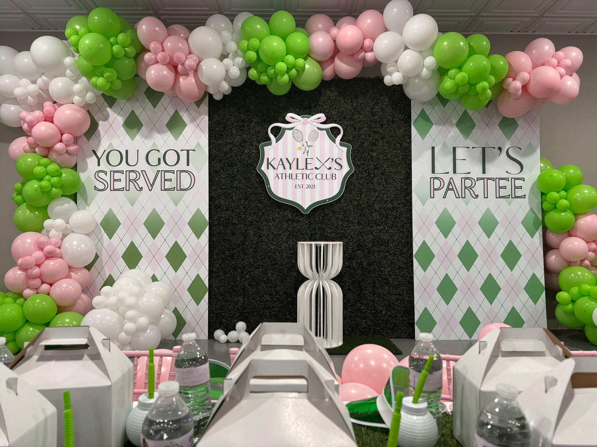Tennis themed birthday backdrop with green and pink balloon garland and custom party signage for kids celebration