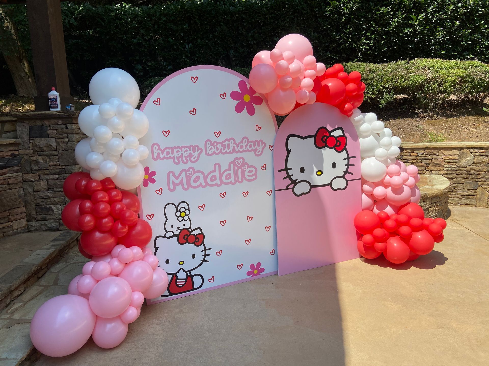 Hello Kitty themed balloon backdrop with custom sign for birthday party