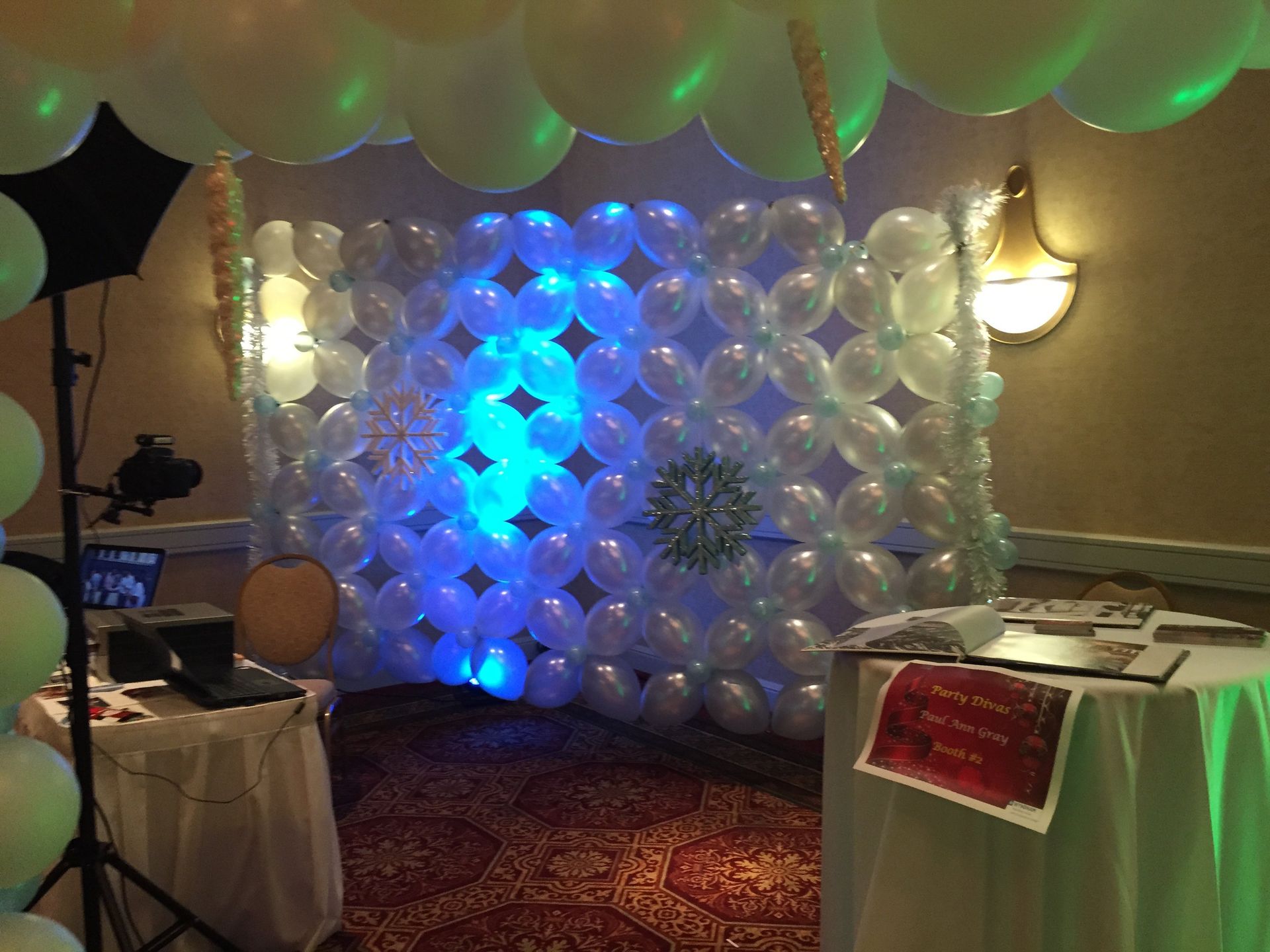 A wall is created with balloons in a neat pattern with snowflakes added on.