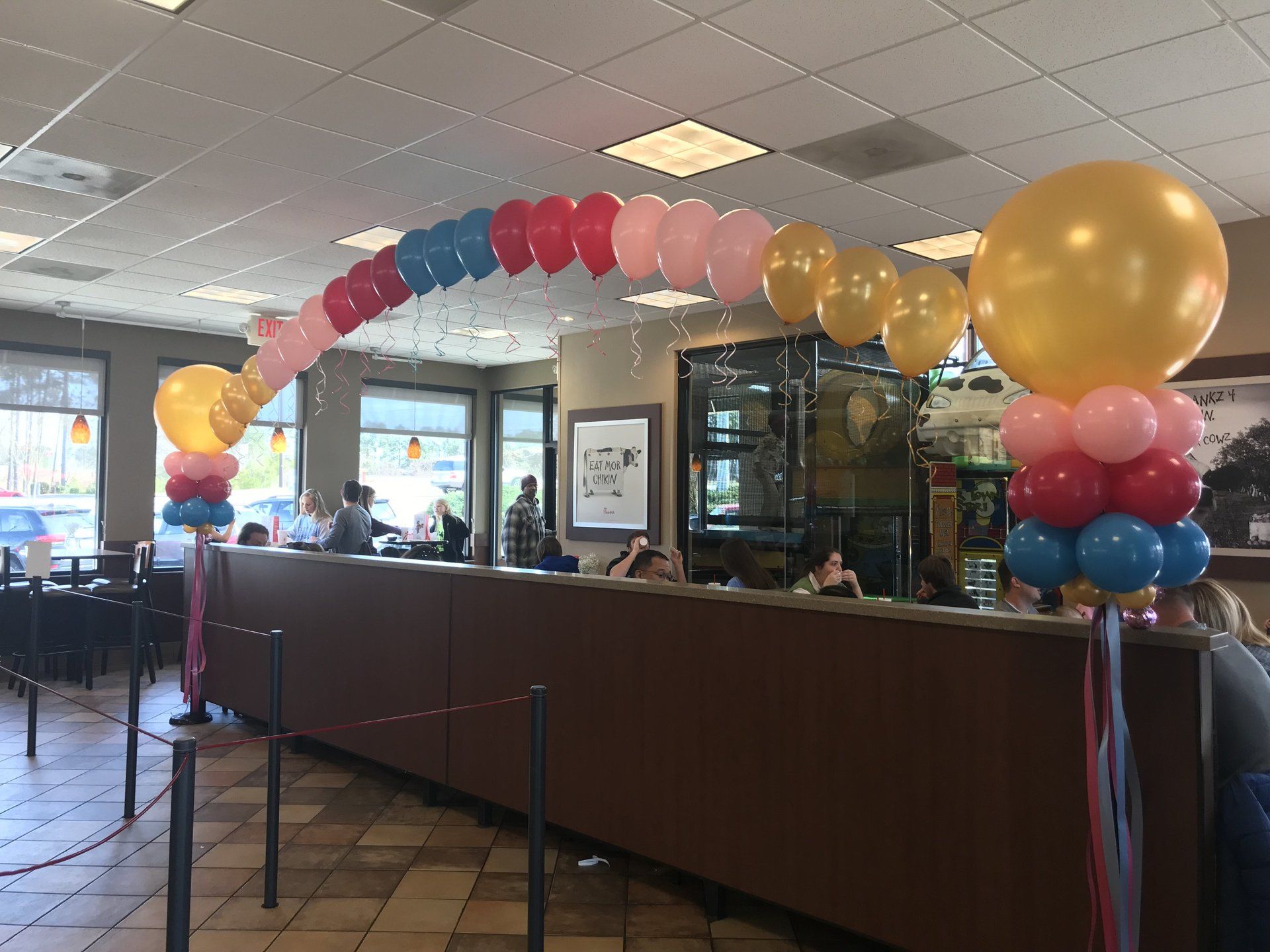 A balloon arch decoration with multiple colors inside of a restaurant