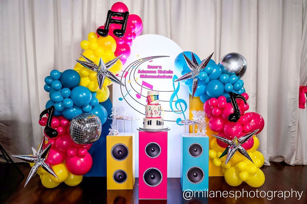 Music themed kids party backdrop with colorful balloons, speakers, and custom signage