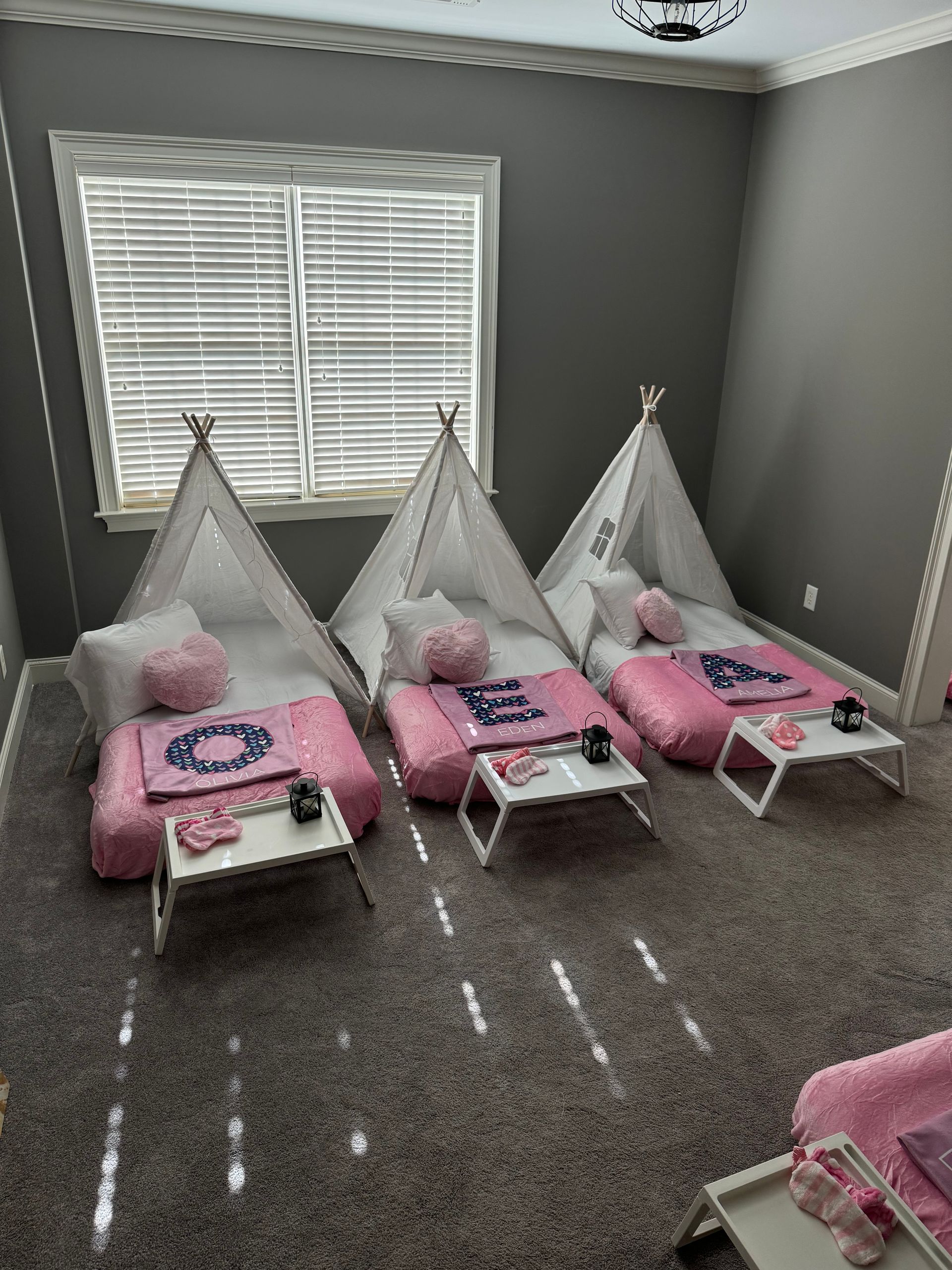 Neutral kids teepee sleepover tents set up indoors for children’s party or cozy playroom experience