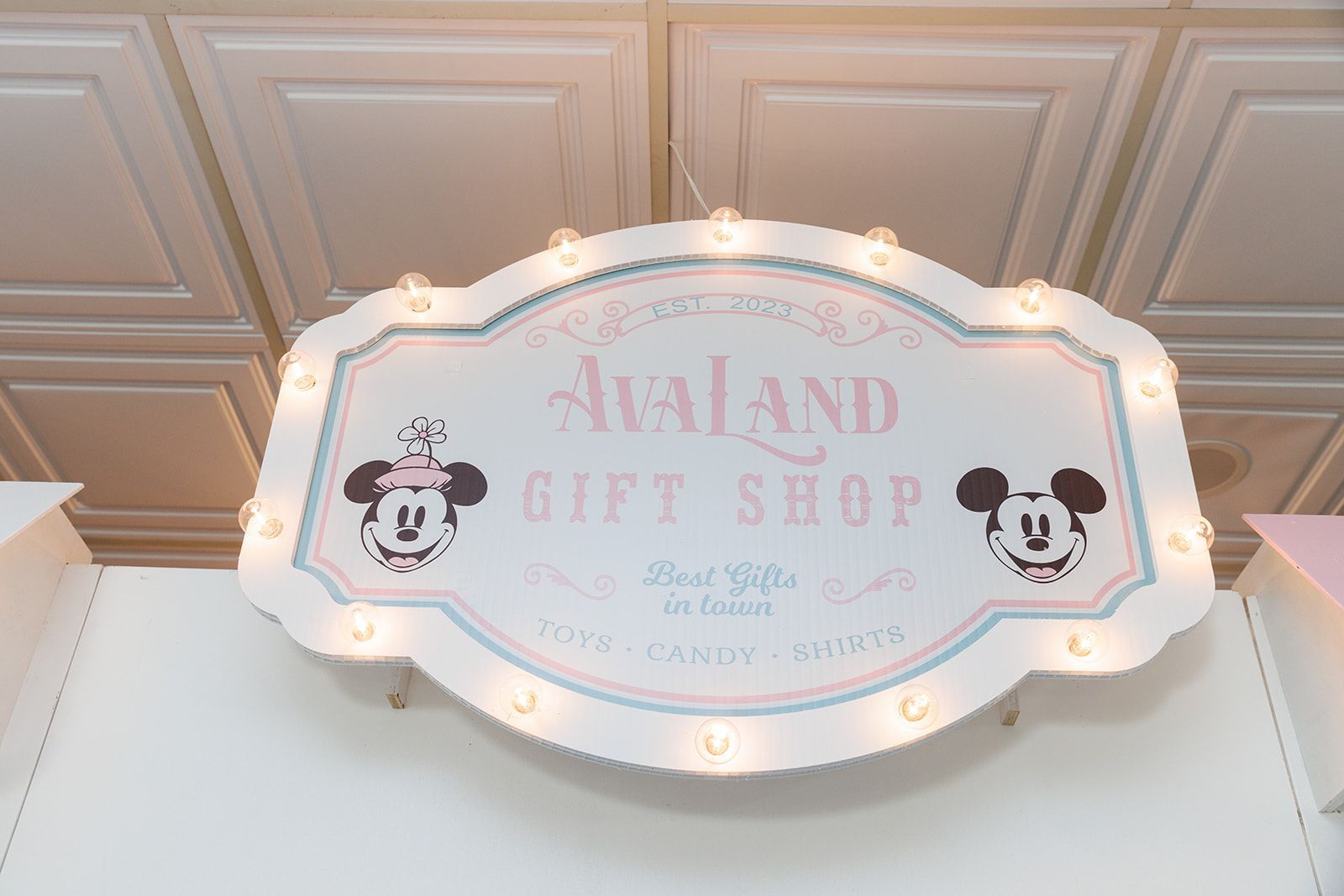 Vintage style “AvaLand Gift Shop” custom party sign with marquee lights for themed kids birthday decor