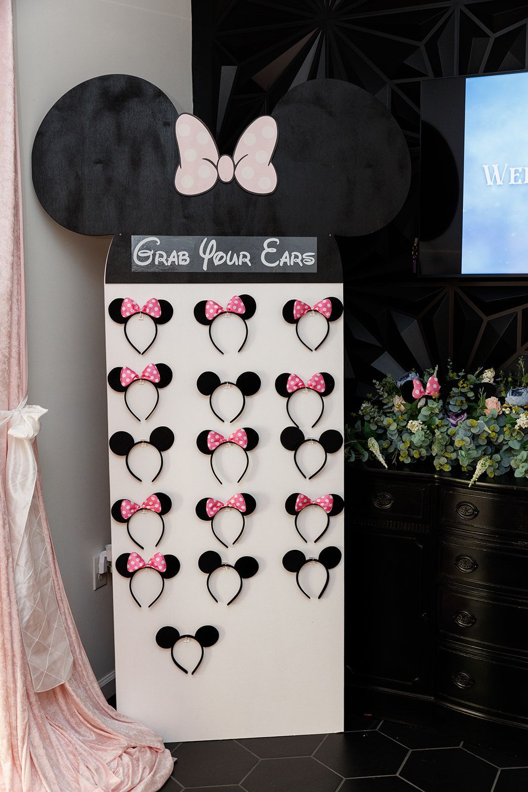 Minnie Mouse ear headband station with “Grab Your Ears” sign for interactive kids party activity table