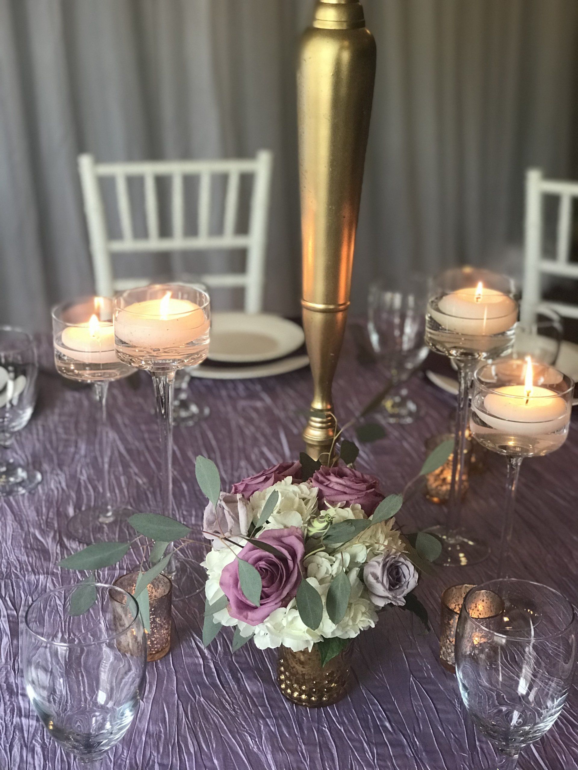Custom designed centerpiece with multiple elements including floral arrangements and candles.