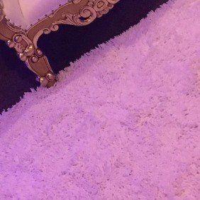 Soft pink shag rug with gold ornate bench for glam photo area or bridal lounge décor