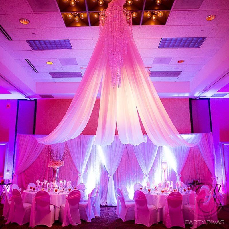 Event design for a wedding with stunning ceiling draping connected to a beaded chandelier.