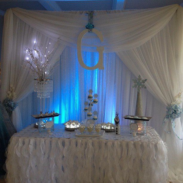 A dessert table presentation with a winter theme. Custom draping for the backdrop with the initial G.