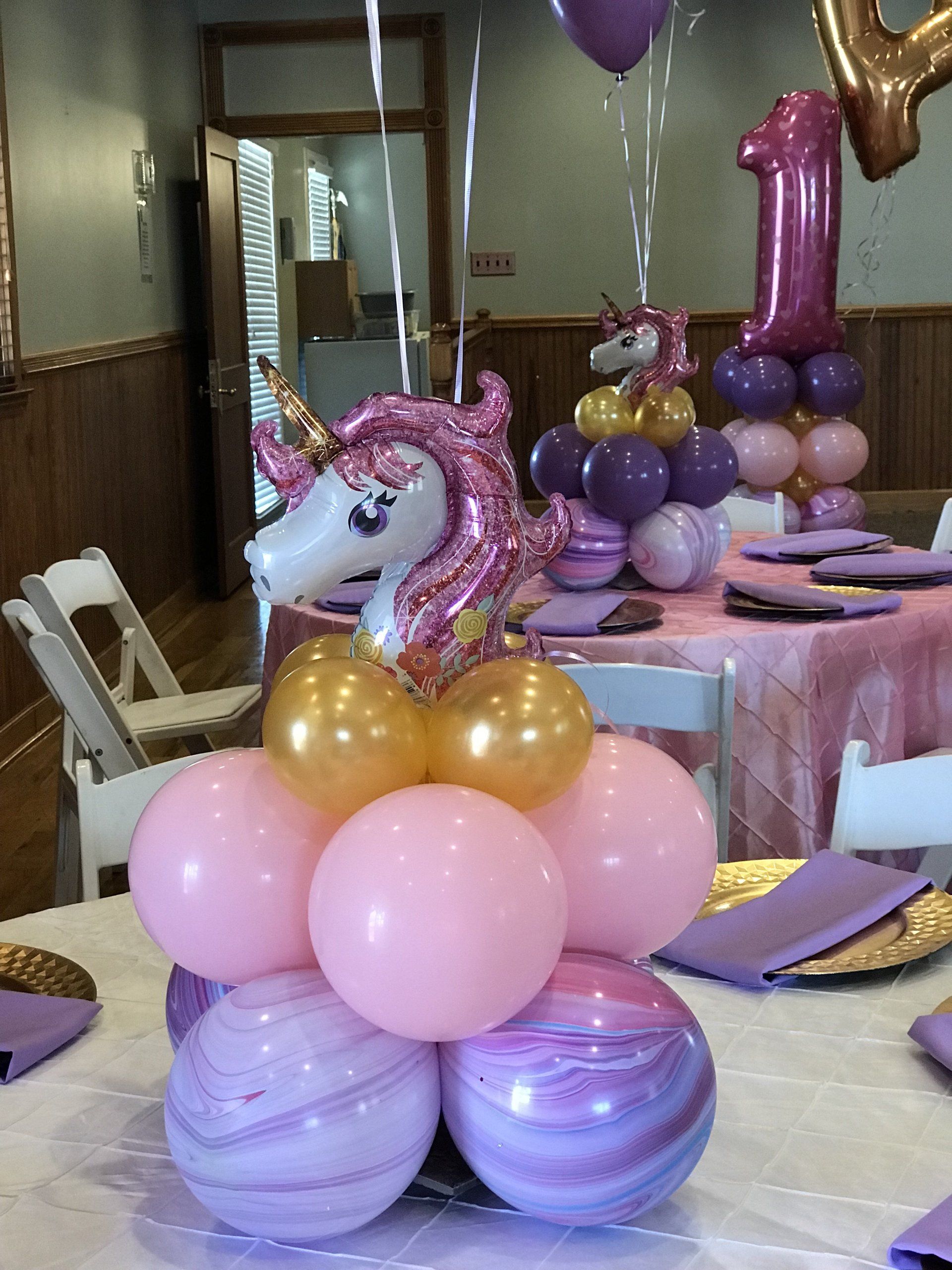 Balloon Centerpieces with a unicorn on top and balloons on strings above.