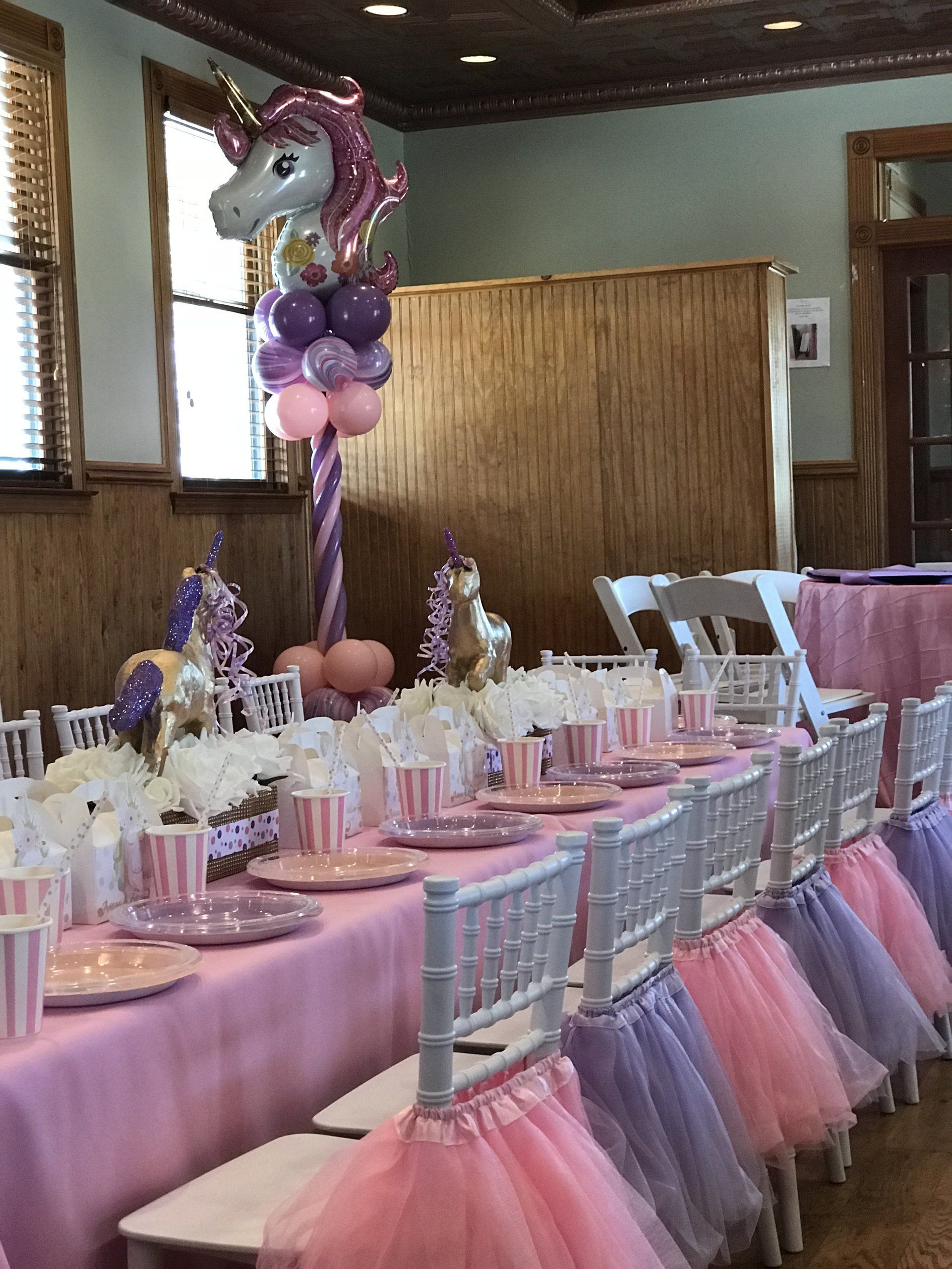 Custom unicorn themed kids birthday party. The banquet (Chiavari) chairs are decorated with pastel pink and purple tutus.