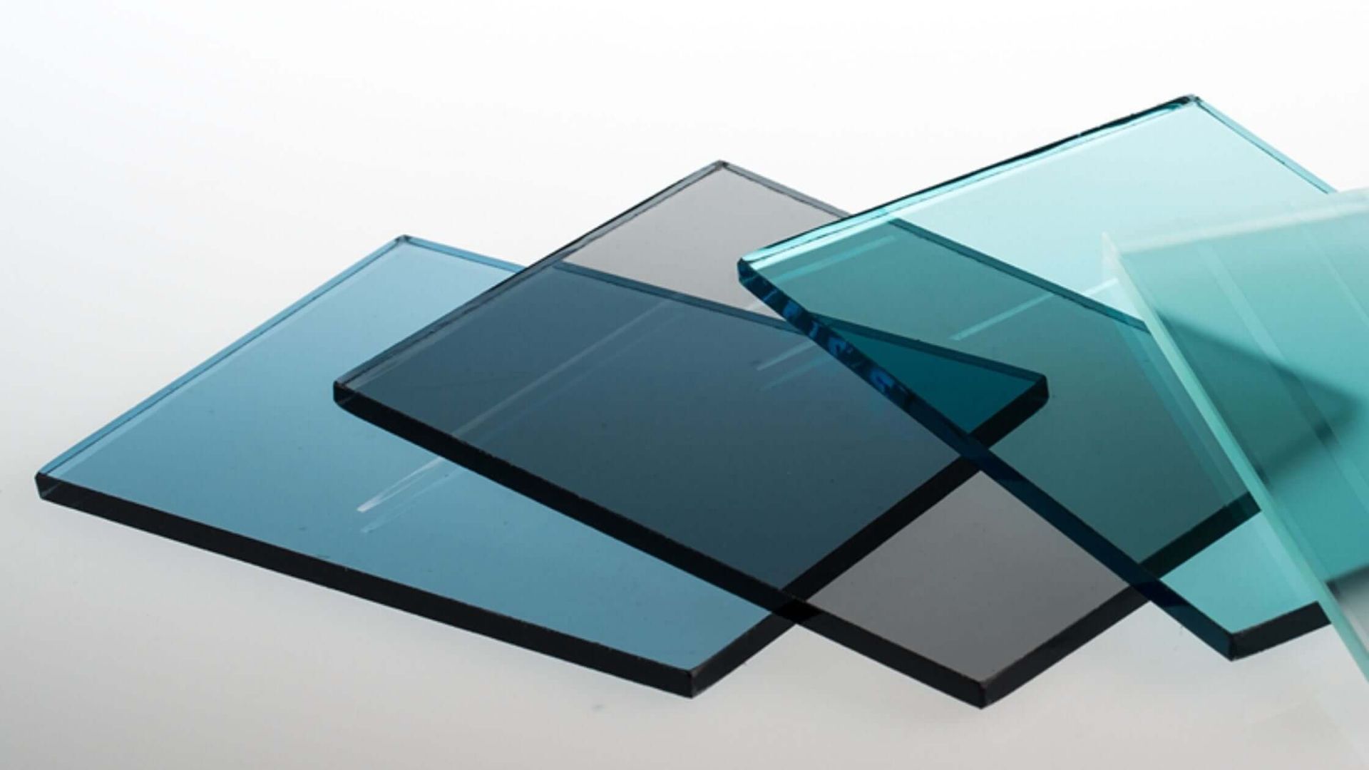 Colored glass panels in shades of blue, teal, and gray overlapping each other against a white background.
