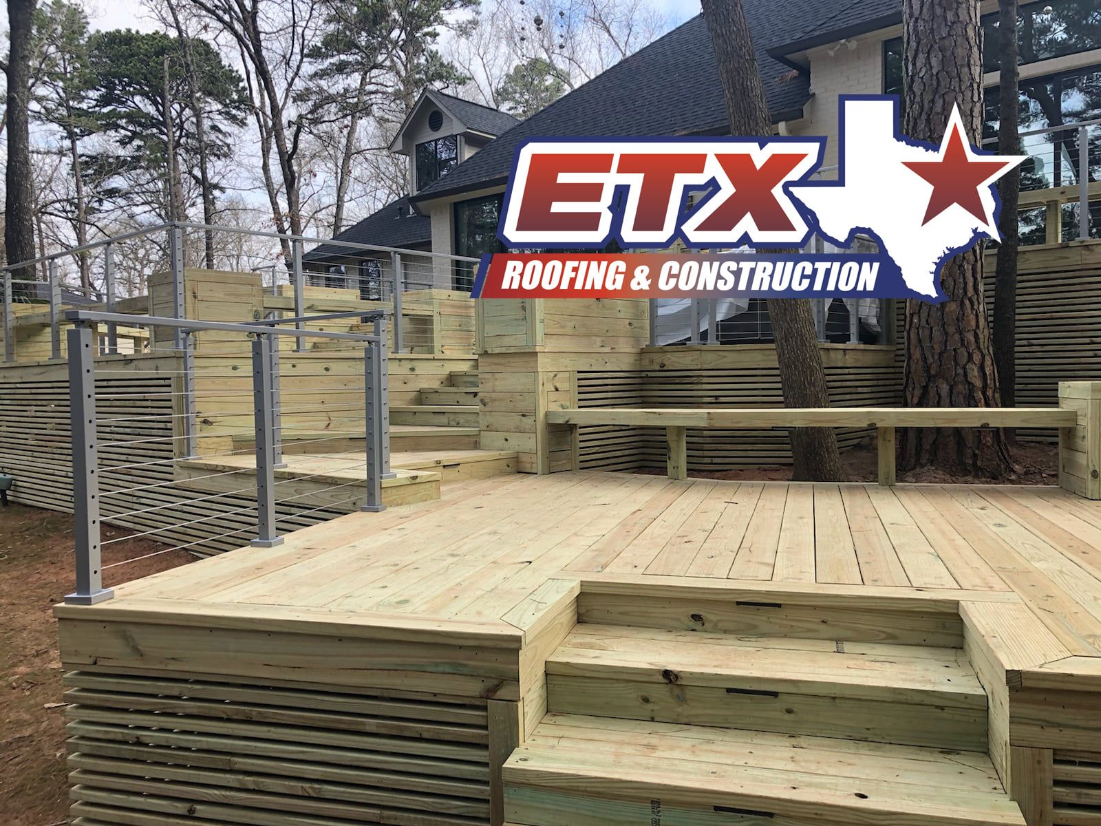 A wooden deck with stairs and a railing in front of a house.