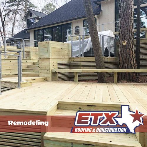 A wooden deck is being built in front of a house.