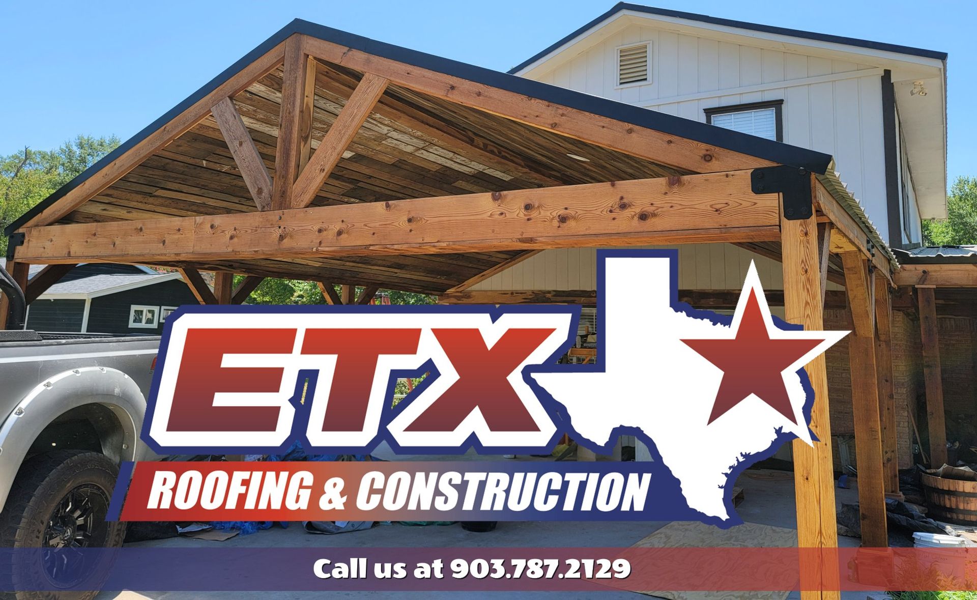 A truck is parked under a wooden structure that says etx roofing & construction
