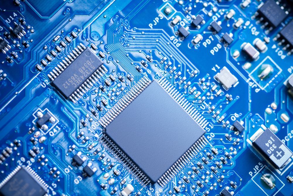 Blue circuit board with microchips and electronic components.