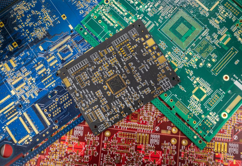 Circuit boards of various colors: blue, green, red, and black, intricately designed with gold traces.