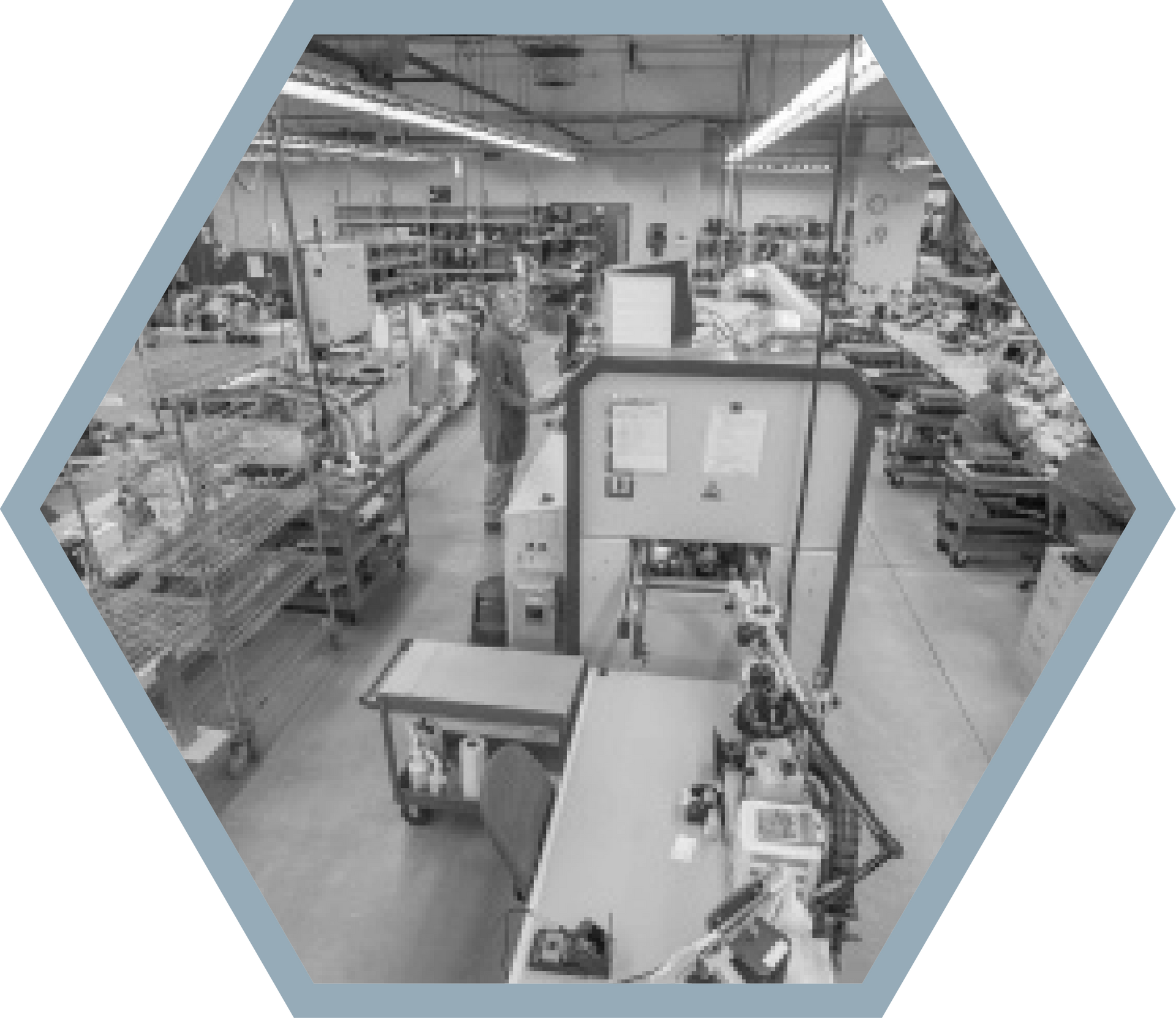 A grayscale overhead view of a manufacturing facility with workers and machinery inside.