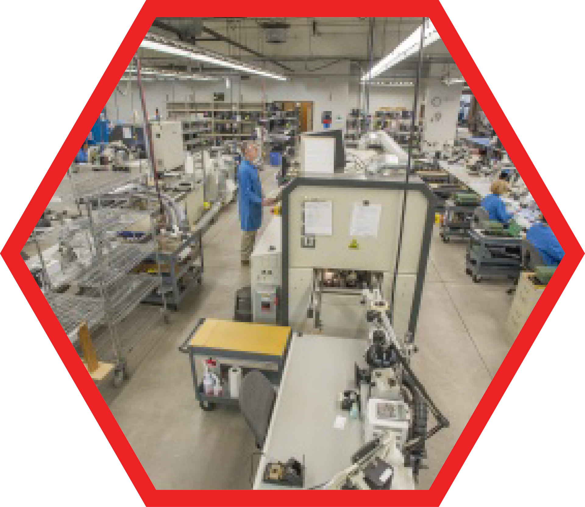 Factory floor with workers in blue, machinery, and equipment.