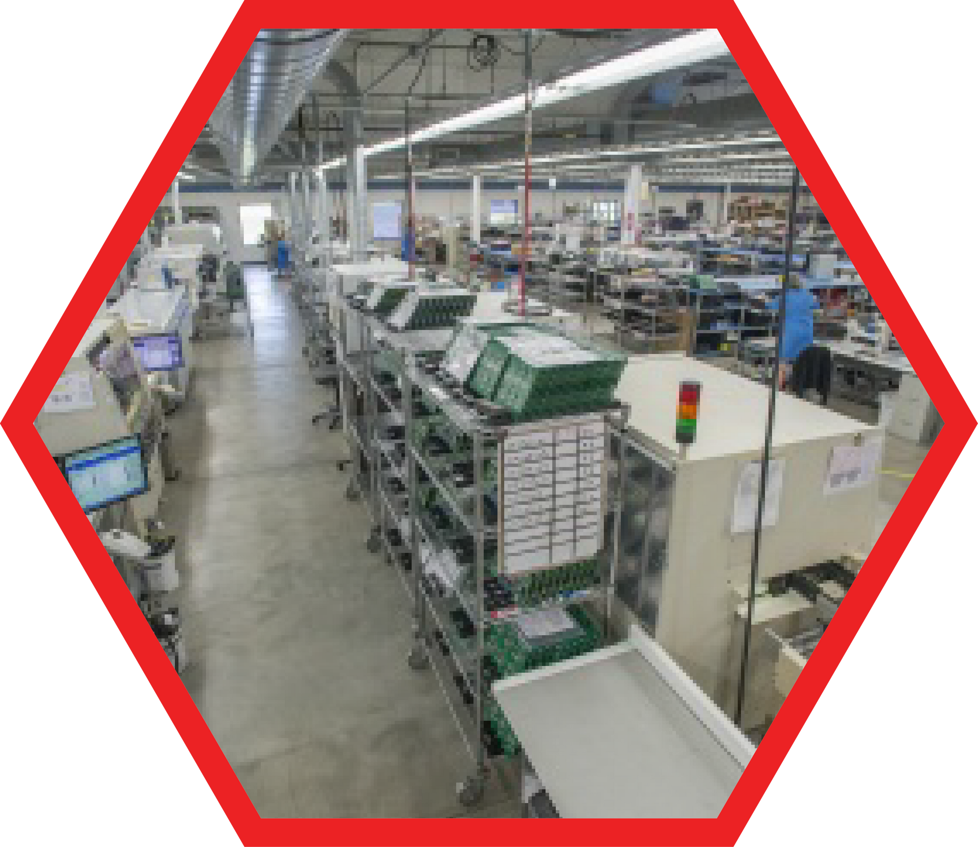 Assembly line in an electronics factory with workers and equipment, inside a red hexagon.