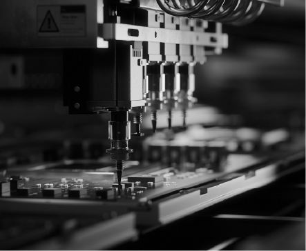 Automated robotic arm placing components on a circuit board in a factory setting.