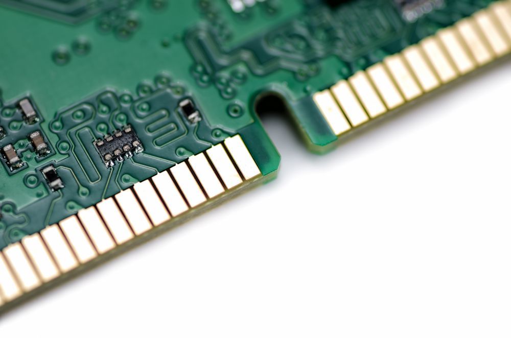 Close-up of a green circuit board with gold connectors on a white background.