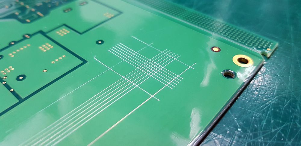 Green circuit board with white lines and copper circles.