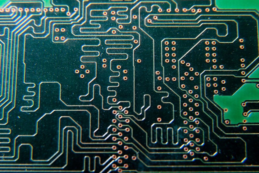 Close-up of a green circuit board with silver traces and components