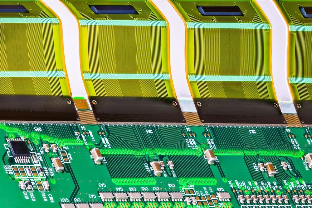 Green circuit board with yellow flex cables connected.