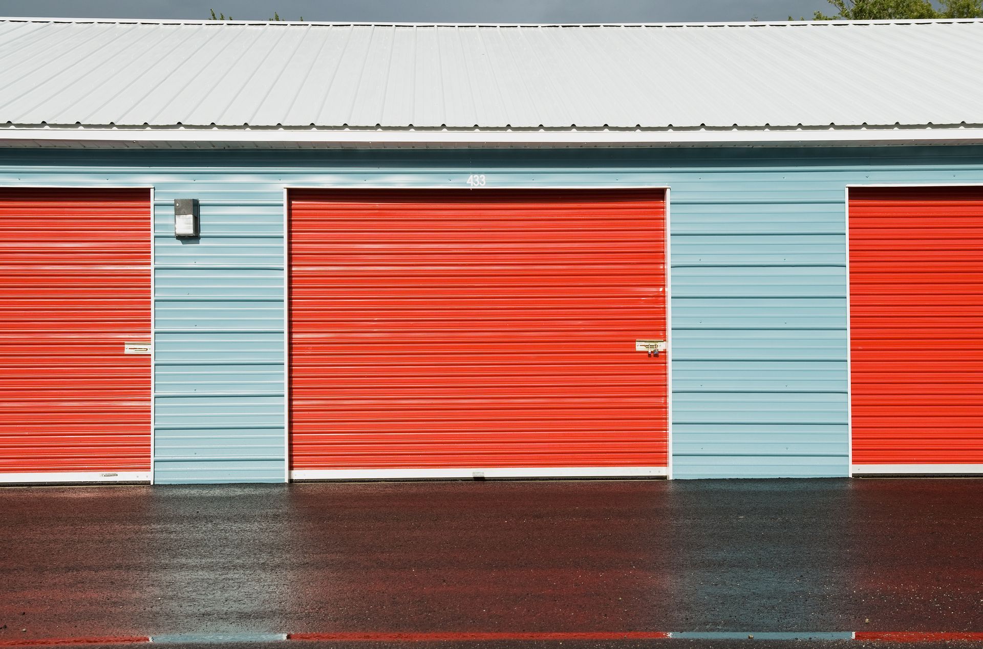 A row of red and blue storage unit with a white roof