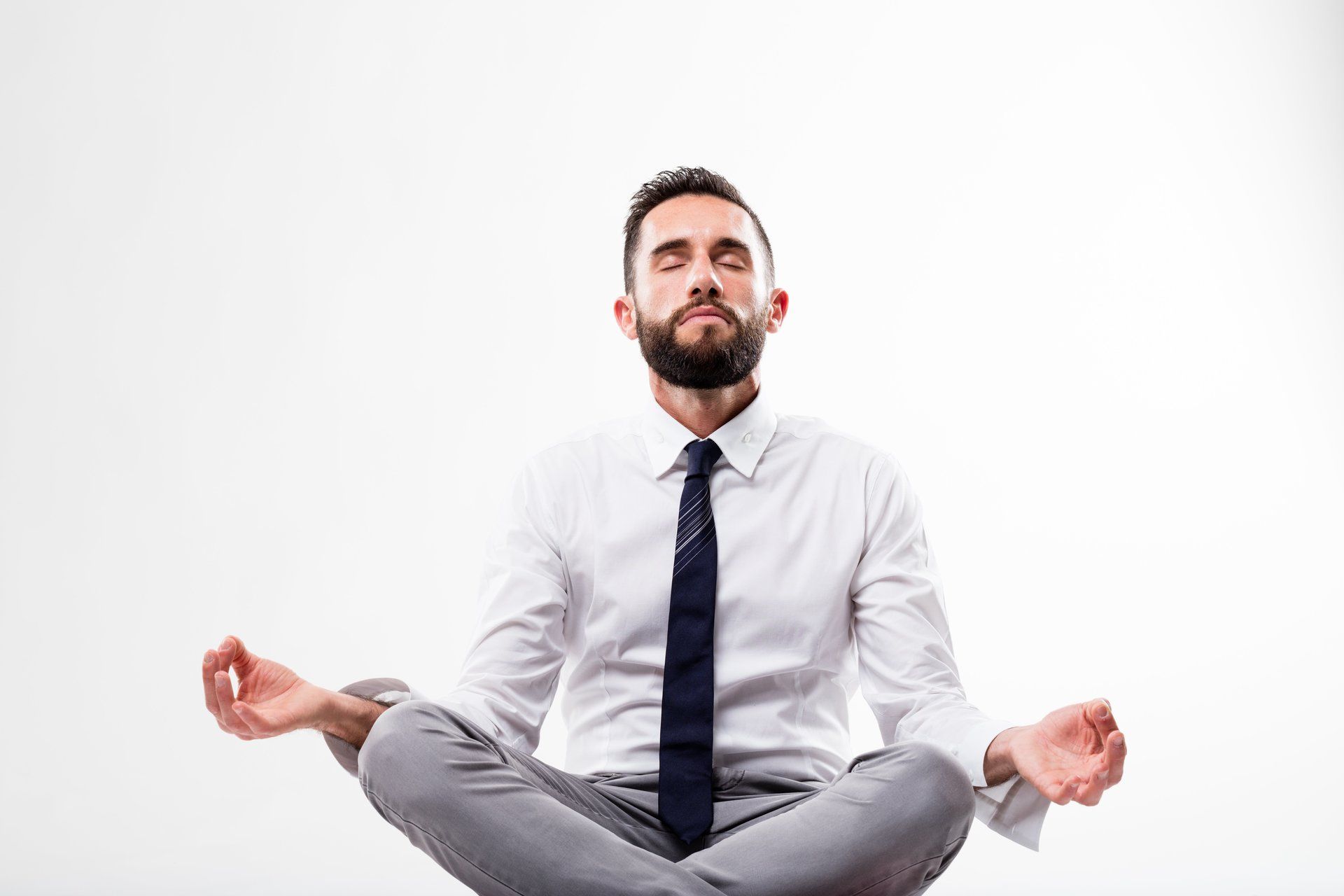 Man in a suit meditating with his eyes closed.