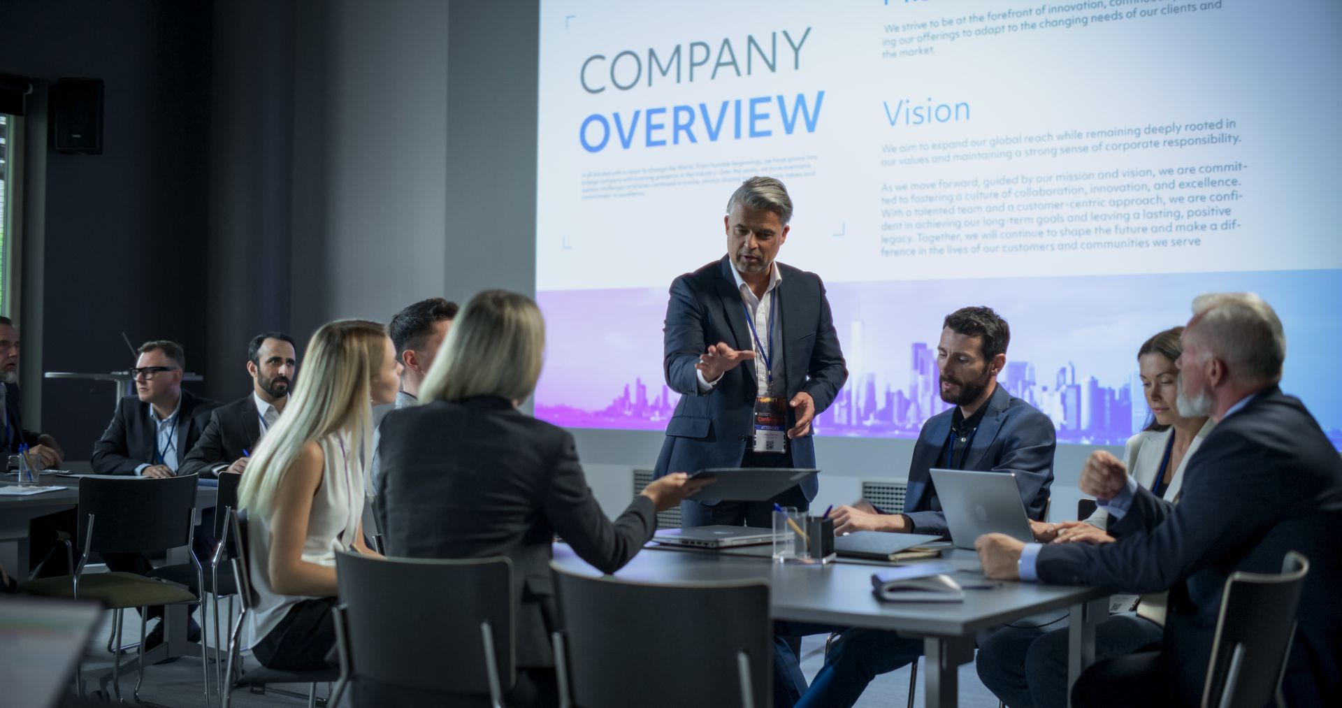 Business presentation: A person gestures toward a screen with 