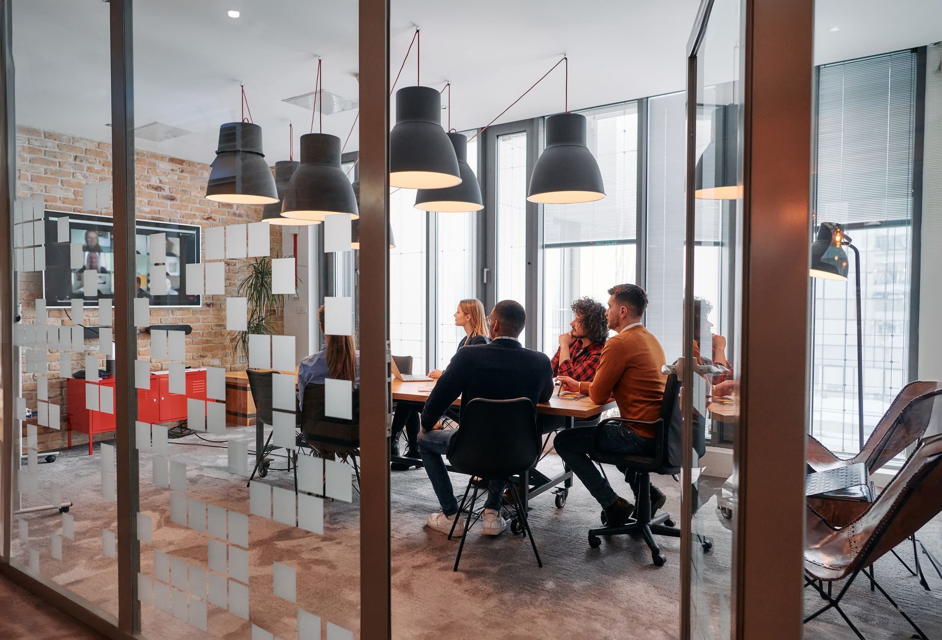 People seated around a table in a modern office conference room, discussing something.