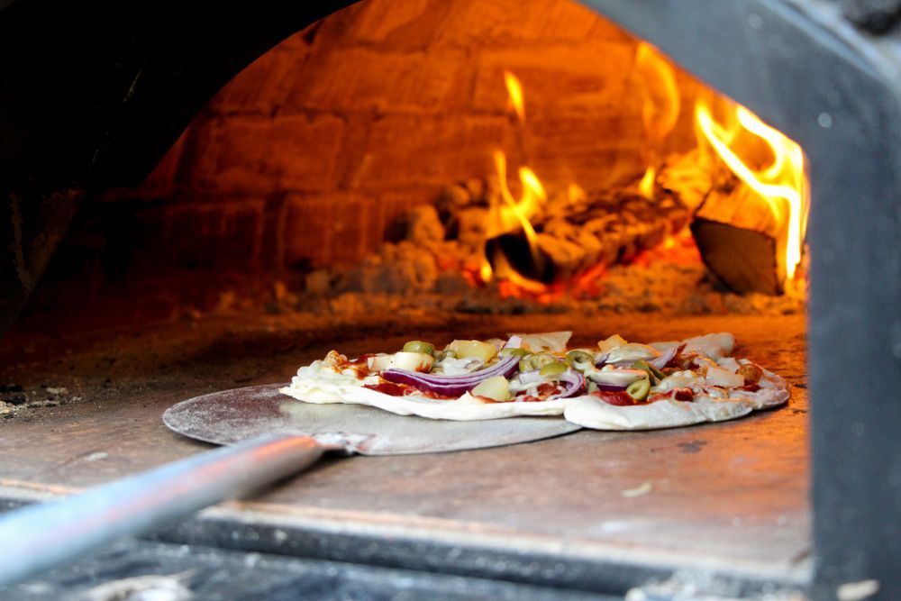 A Pizza is Being Cooked in a Brick Oven — Mumbo's Pizza'n'Pasta In Lismore, NSW