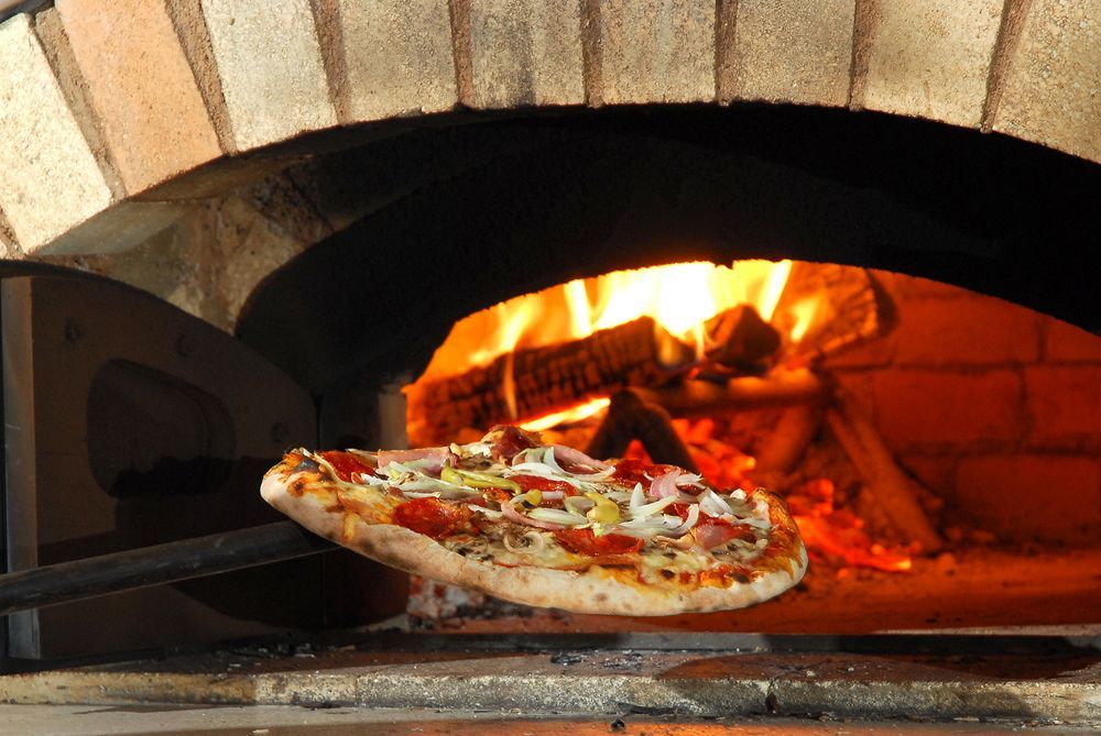 A Pizza is Being Cooked in a Brick Oven — Mumbo's Pizza'n'Pasta In Lismore, NSW