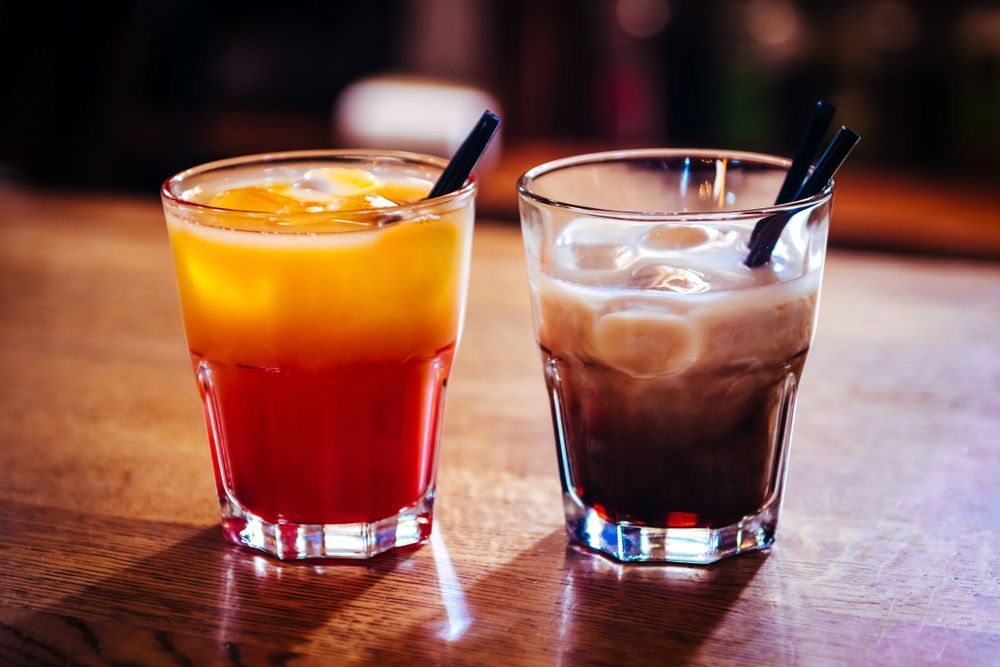 Two Glasses of Drinks With Straws on a Wooden Table — Mumbo's Pizza'n'Pasta In Lismore, NSW