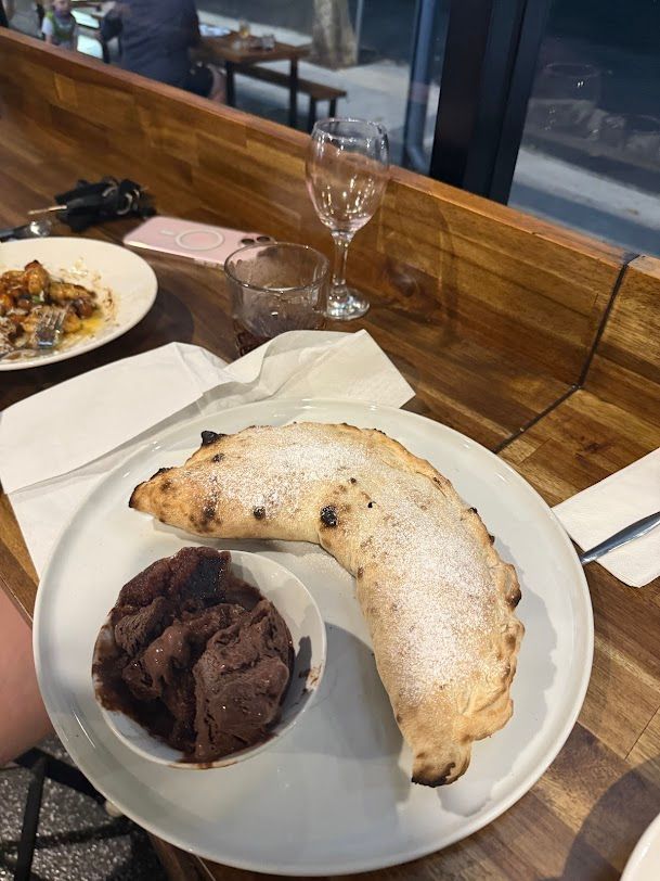 A White Plate Topped With A Pizza And Ice Cream On A Wooden Table — Mumbo's Pizza'n'Pasta In Lismore, NSW